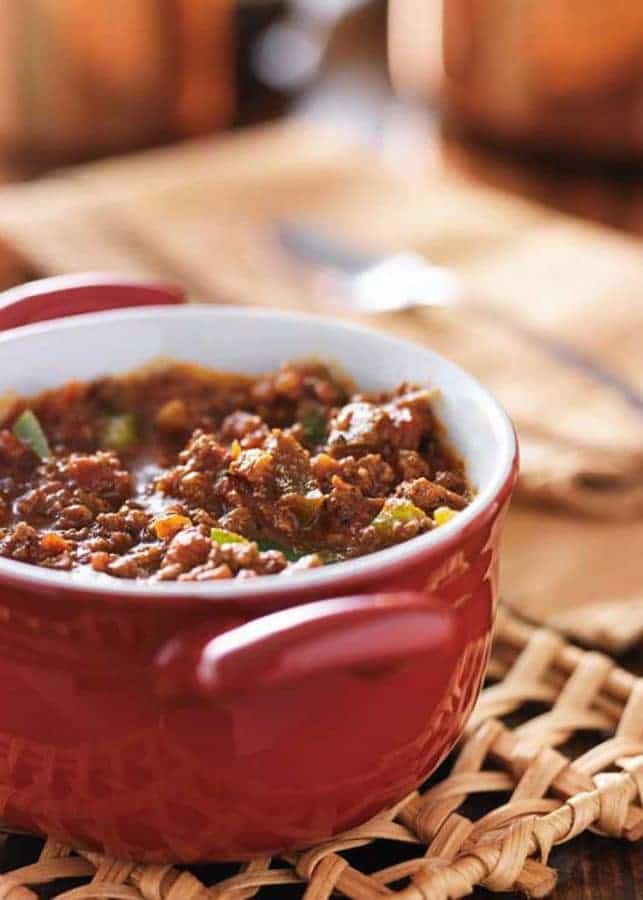 game day chili made with ground meat and beans, being served in a red crock