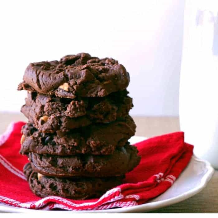 peanut butter chocolate chip cookies stacked on a white plate