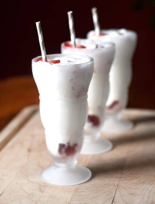 three glasses of Strawberry Ice Cream Soda with a metallic straw sticking out