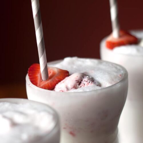 Strawberry Ice Cream Soda closeup in a glass with strawberry ice cream and soda on top