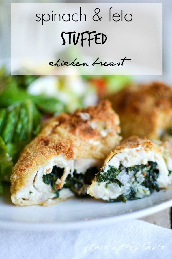 Spinach and feta stuffed chicken breast sliced open to show the filling, served on a white plate with a green salad