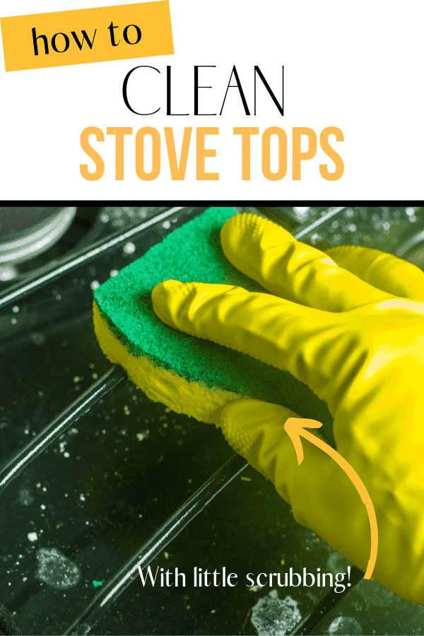 gloved hand holding a scouring pad and cleaning the grate of a green gas stove top to show how to clean a gas stovetop