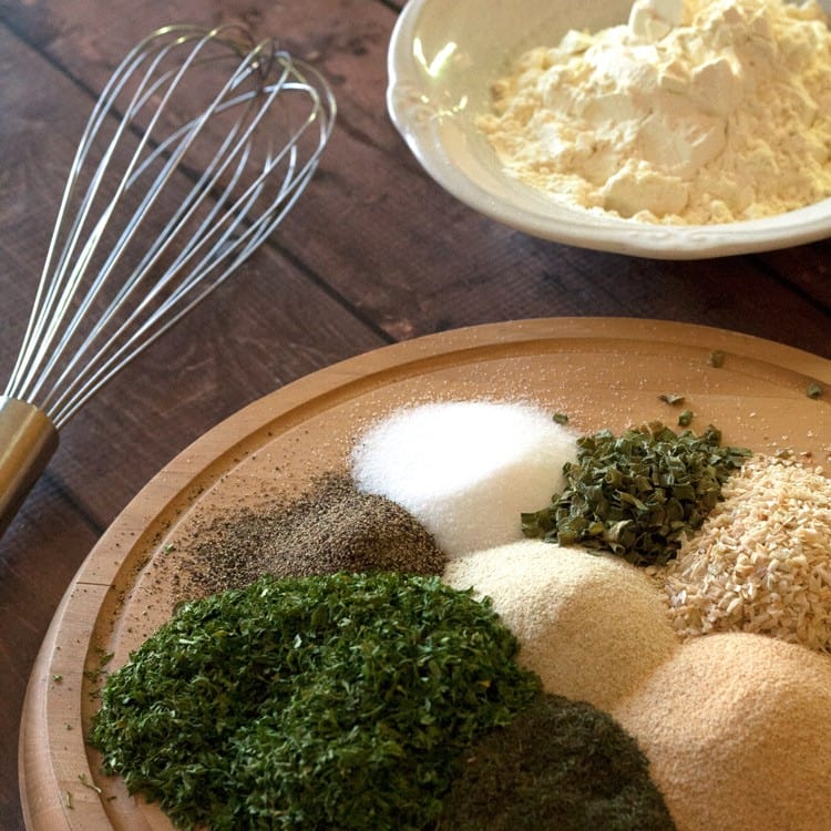 ranch dressing mix ingredients on a light wooden platter next to a wire whisk