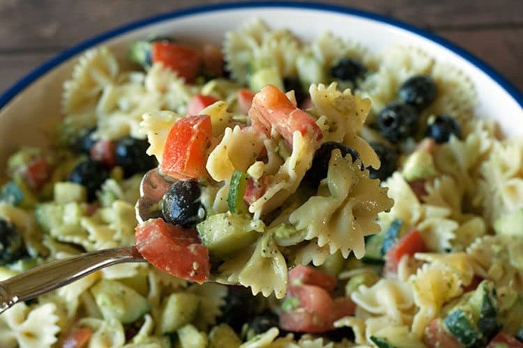 closeup of avocado salad recipes in a fork over a bowl