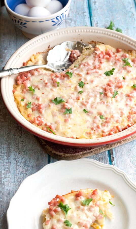 Overnight southwest breakfast casserole on a plate next to a bag of Simply Potatoes shredded hash browns