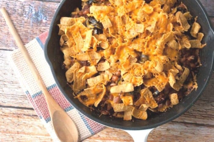 chili corn chip casserole being served on a wood table