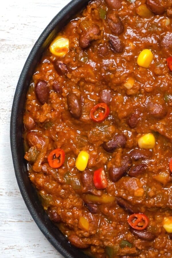 closeup of texas chili garnished with slivered peppers