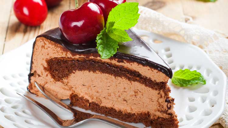 chocolate mousse cake with cherries on white plate