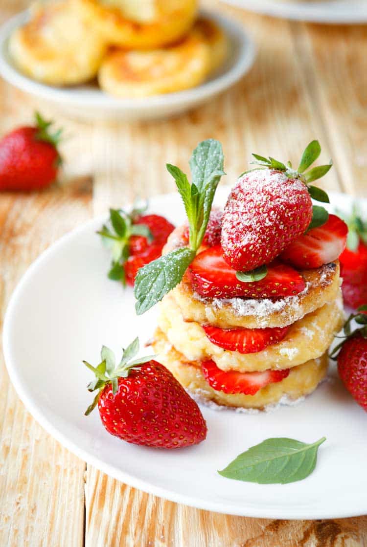 pancakes with strawberries on wood background