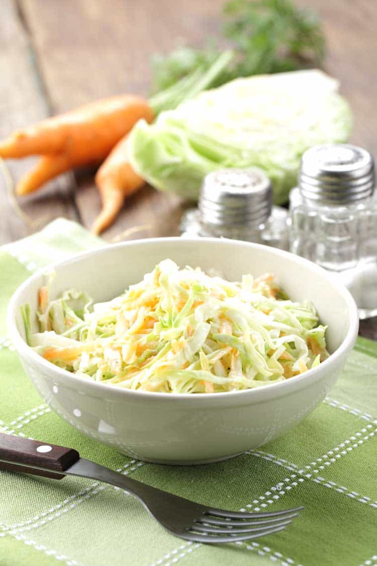 bowl of coleslaw in white bowl on green placemat