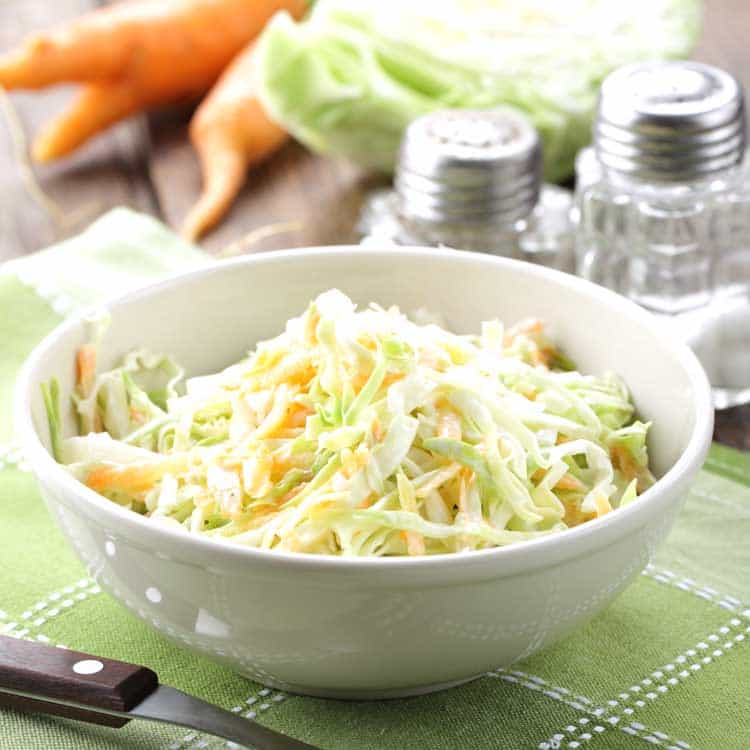 bowl of coleslaw in white bowl on green placemat