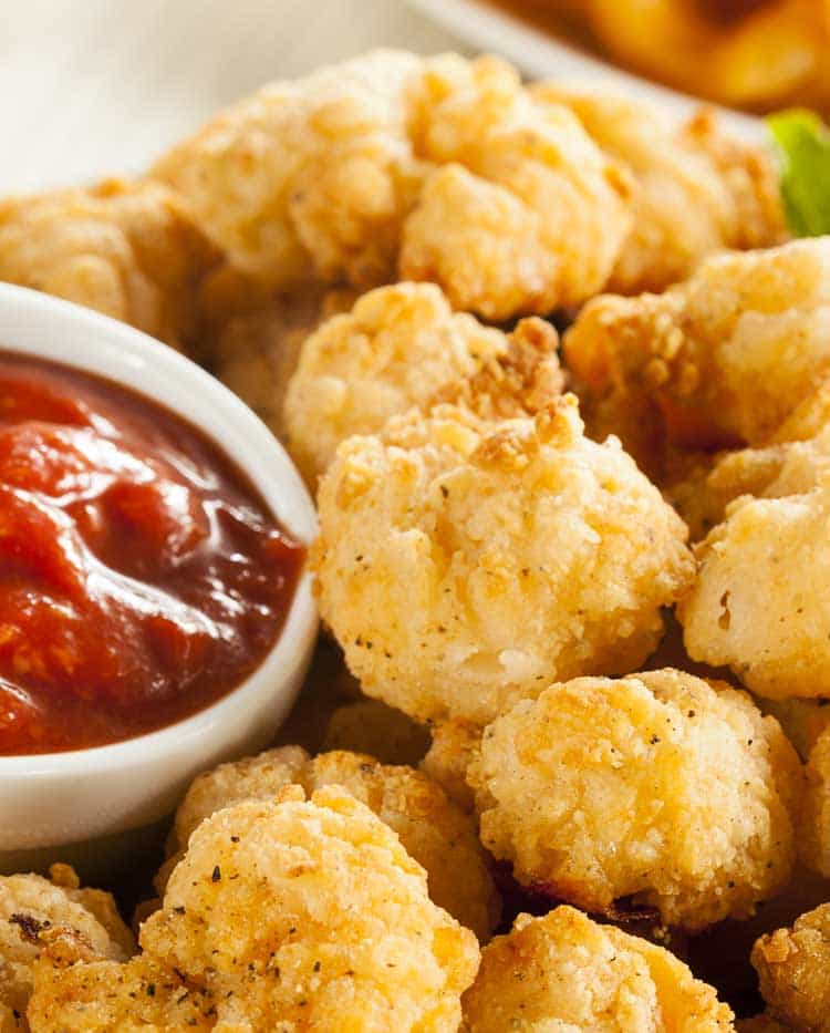 fried shrimp with cocktail sauce on white plate