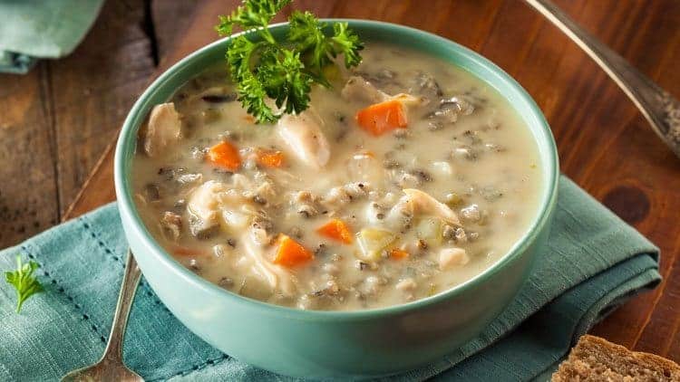 copycat panera chicken and wild rice soup being served in a blue bowl