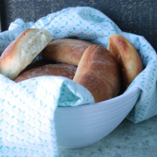 easy yeast rolls wrapped in blue and white towel in white bowl