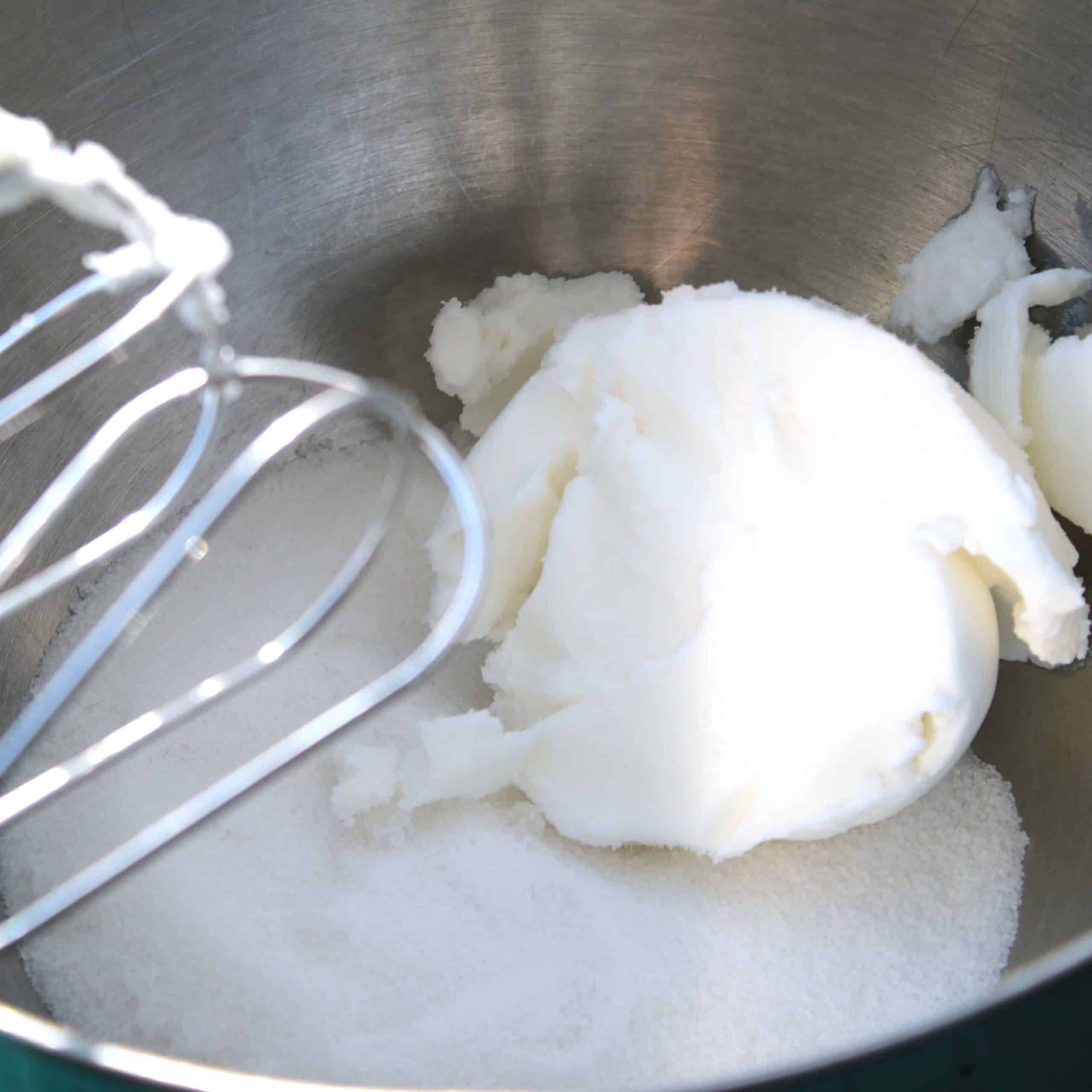 bowl containing crisco with mixing whisk on the side in process of making easy yeast rolls