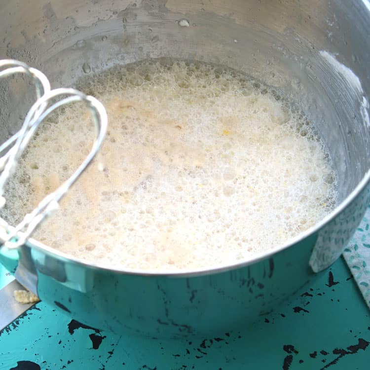 bowl containing bubbly mixture of crisco, sugar, water, and eggs while making easy yeast rolls