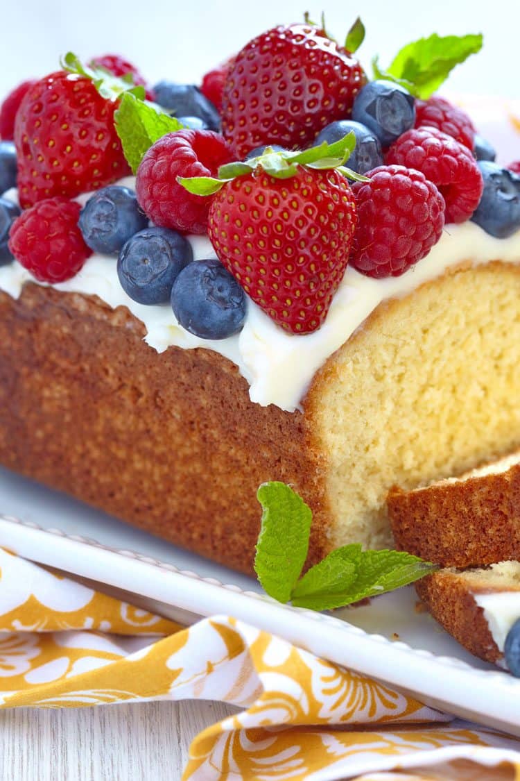 pound cake dessert with white chocolate sauce and berries