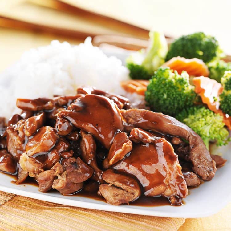 bourbon street chicken with rice and broccoli on white plate