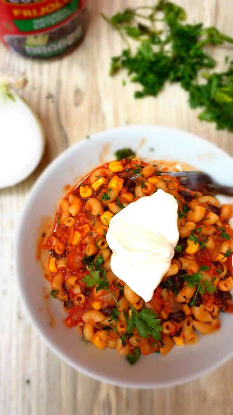 one pot chili mac being served with a dollop of sour cream