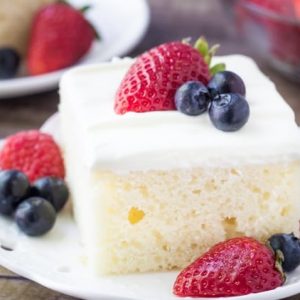This berries and cream sheet cake is perfect for summer. It's a delicious vanilla sheet cake with a soft cake crumb. Then it's topped with a cream cheese topping & fresh berries.