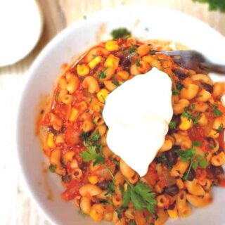 Overhead view of one-pot southwest chili mac topped with sour cream and cilantro