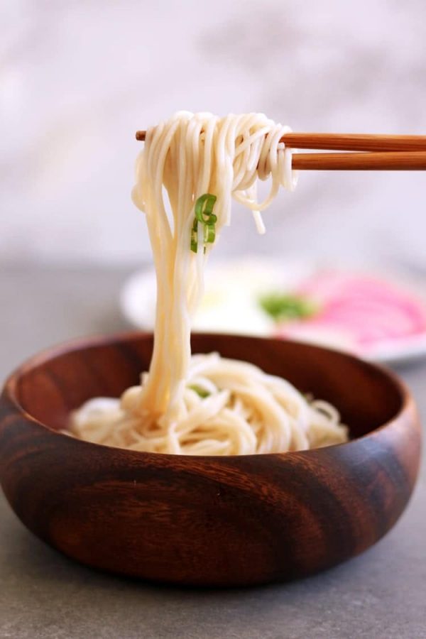 cold somen noodles being twirled on chopsticks
