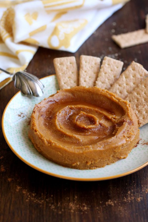 Dessert pumpkin hummus swirled on a plate with graham crackers and a dusting of pumpkin pie spice