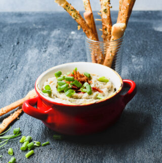 This creamy rosemary white bean dip is served with a side of parmesan breadsticks for a tasty fall party snack.