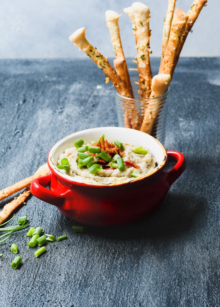 This creamy rosemary white bean dip is served with a side of parmesan breadsticks for a tasty fall party snack. 