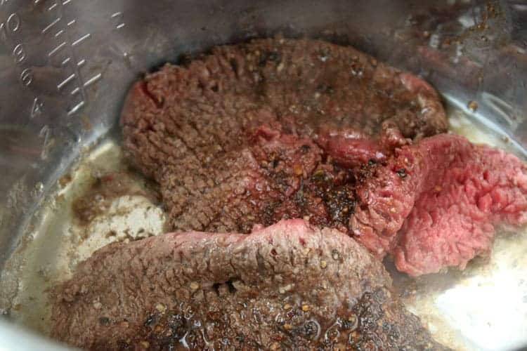 inside of instant pot with cube steak recipes browning and oil on surface of instant pot
