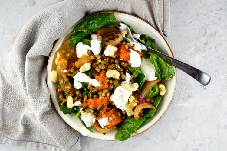 Overhead shot of a squash salad with feta cheese, lentils and spinach