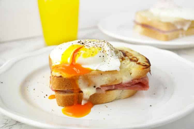 A close up of easy croque madame and a poached egg with dripping yolk