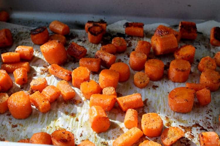 roasted carrots on parchment paper lined roasting pan