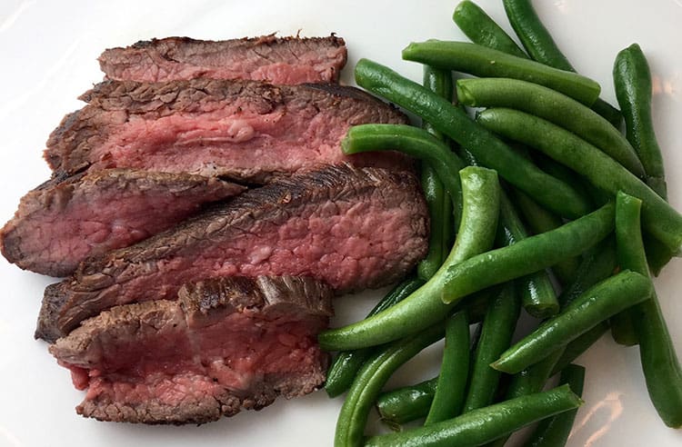 steak and green beans on white plate