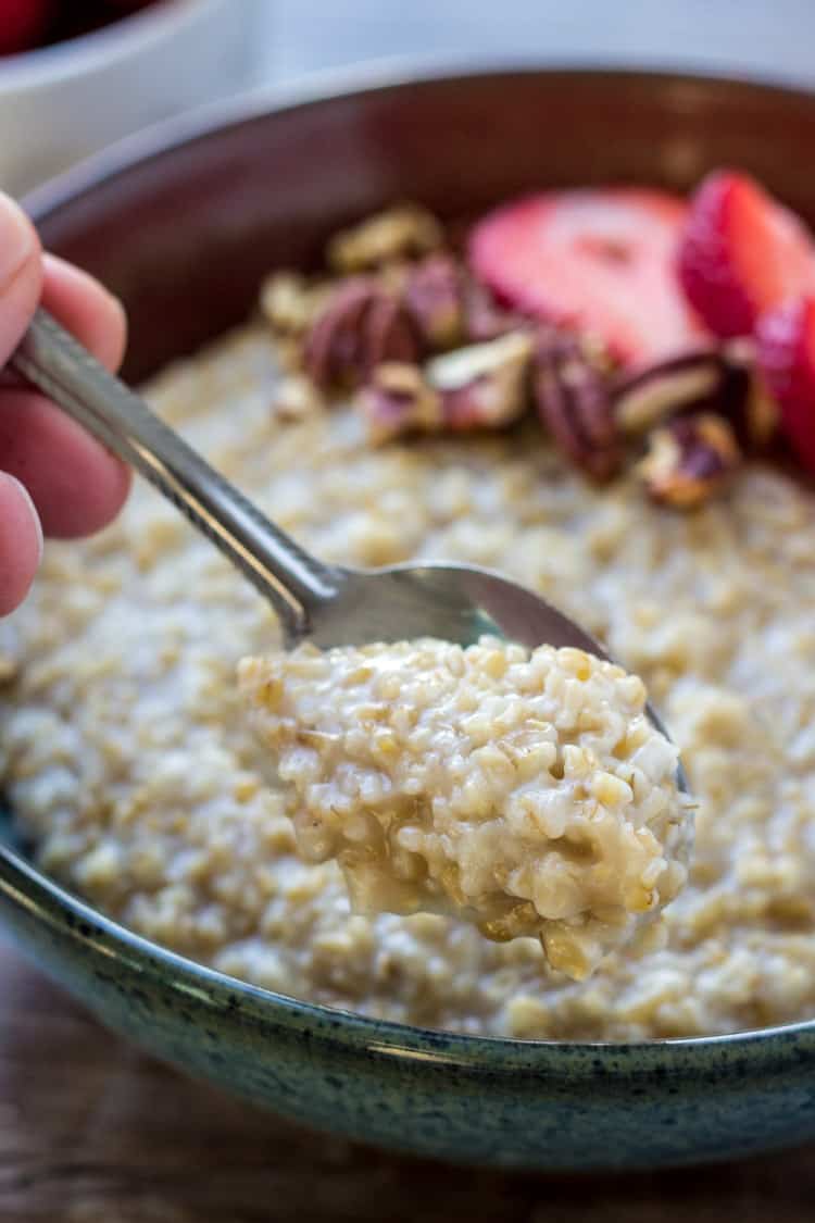 closeup of hand holding a spoon containing Instant Pot steel cut oats