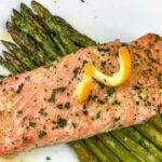 Permalink to: Orange-Glazed Salmon with Asparagus salmon plated over asparagus on white square plate