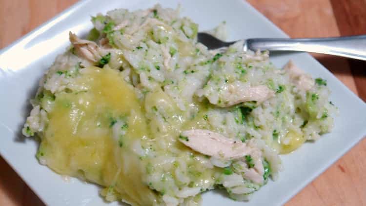 Chicken, broccoli, and rice casserole on a white square plate with spoon