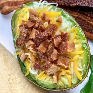 overhead view of baked avocado loaded with cheese and bacon bites
