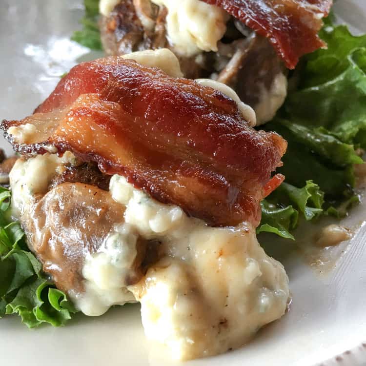 keto hamburgers with bacon over melted blue cheese and mushrooms over lettuce