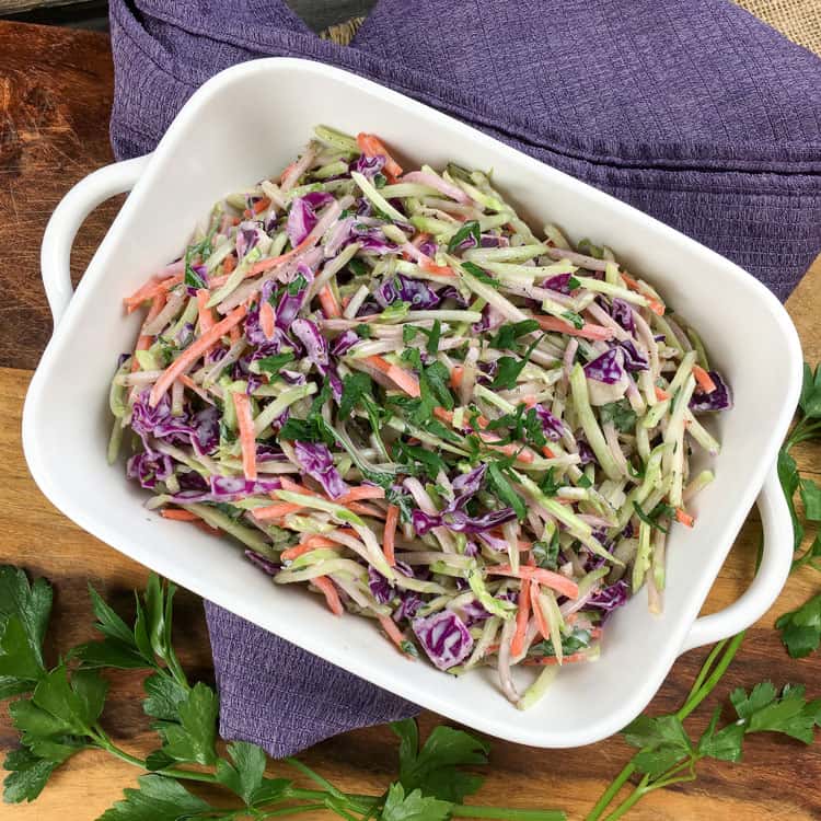 overhead view of keto slaw in white serving platter on top of blue folded towel