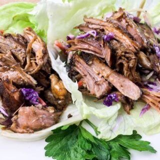 easy keto lettuce wraps containing pulled pork and red cabbage inside a piece of lettuce
