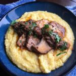 Permalink to: Braised Tuscan Pork Shoulder Roast sliced roasted pork butt on creamy polenta on a blue plate