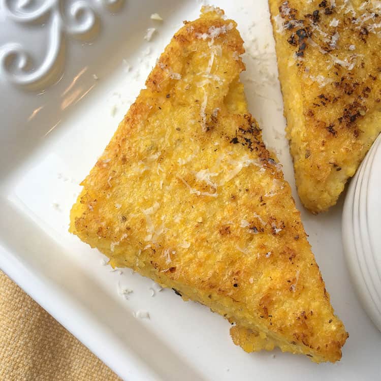 how to make polenta with an upclose view of fried polenta on a white serving dish