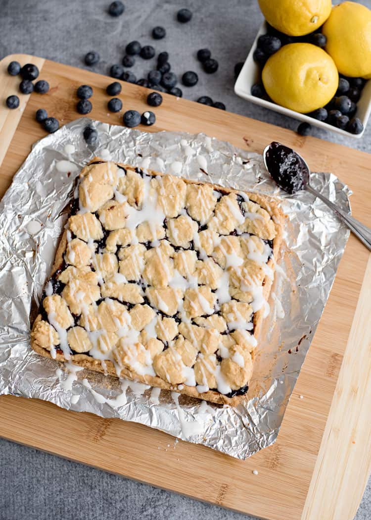 Baked Blueberry Lemon Crumble Bars with powdered sugar and lemon juice drizzle.
