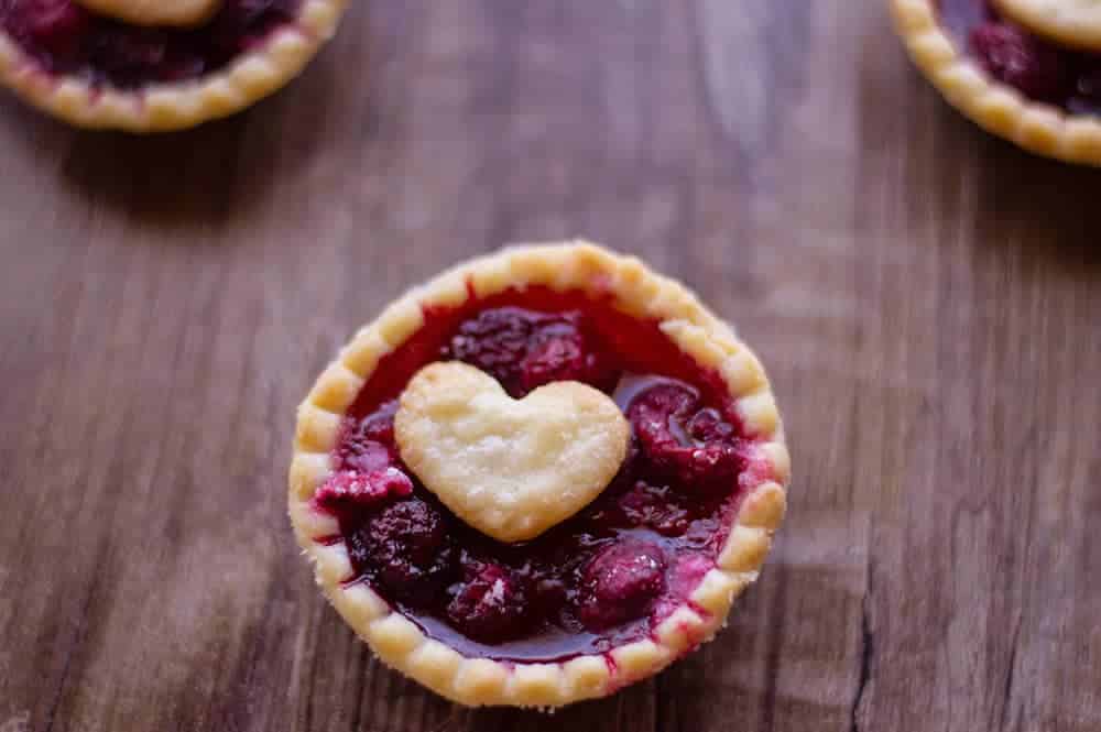 Easy raspberry tarts with heart center on wooden table
