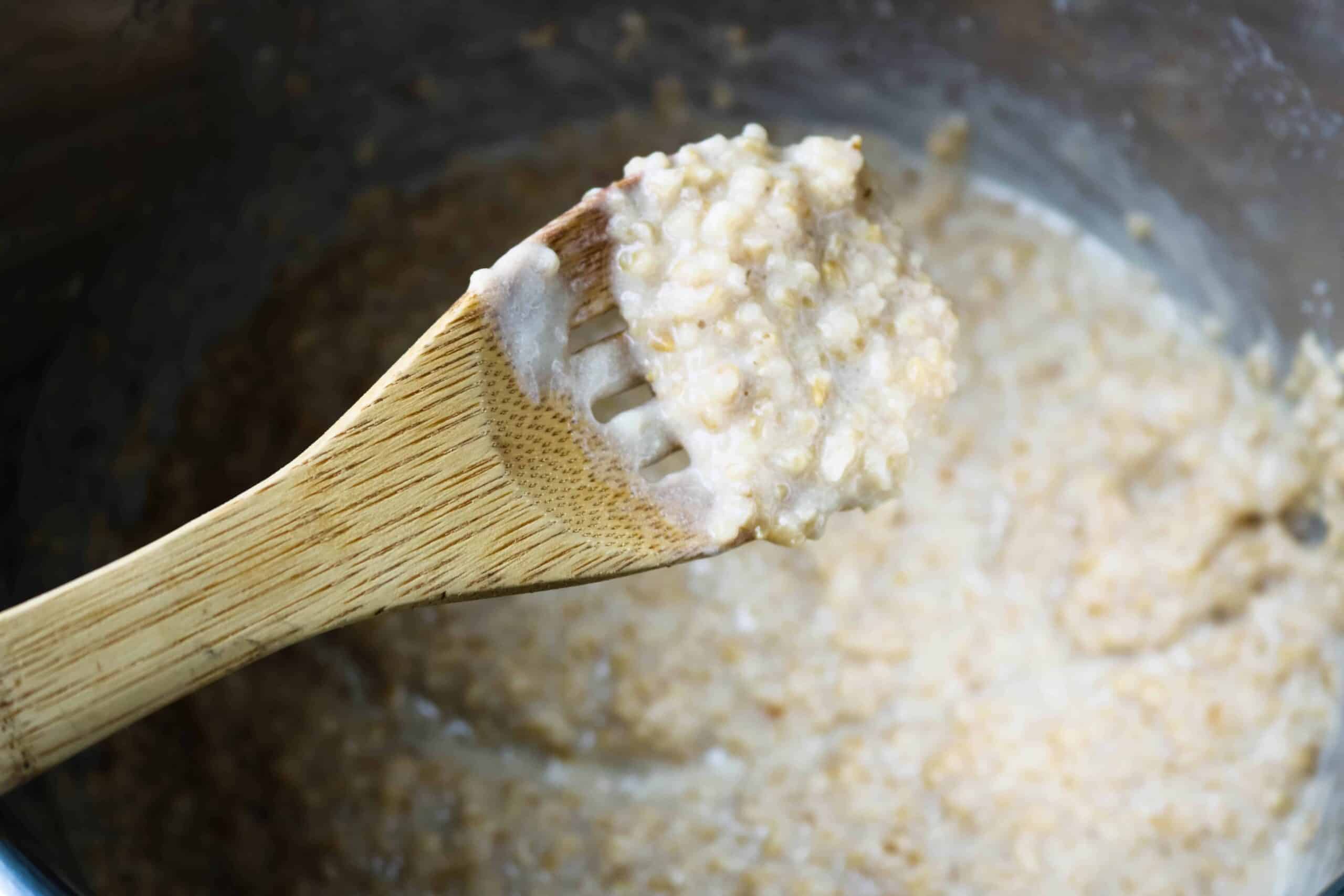 close up of a scoop of the cooked Oatmeal on a wooden spoon