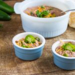 Two portions of Instant Pot Refried Beans served in light blue ramekins