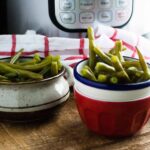Permalink to: Instant Pot Green Beans Recipe Instant Pot Green Beans served in red and white bowls next to a red checked cloth napkin