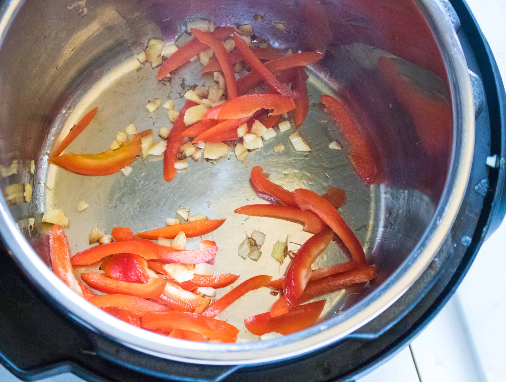 Ginger, garlic and sliced peppers in sesame oil inside an Instant Pot