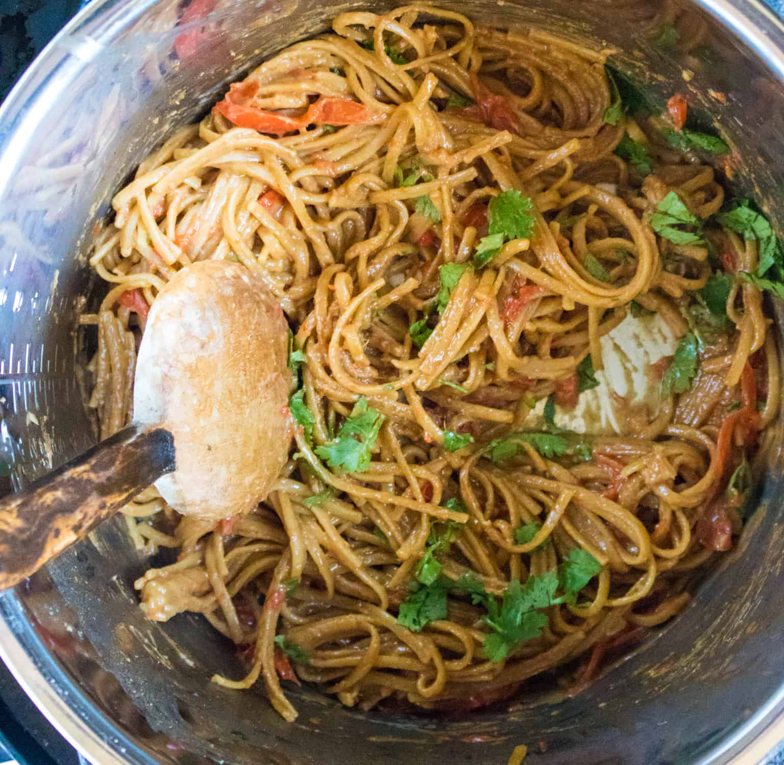 Thai Peanut Noodles in an Instant Pot being stirred with a spatula